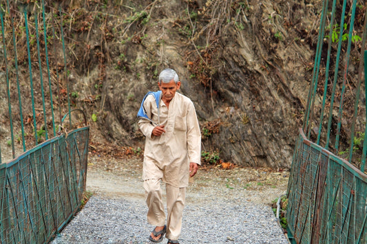 man in white thobe standing on gray concrete pathway during daytime