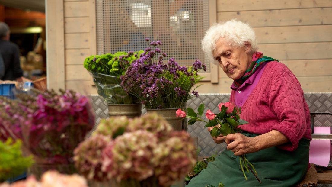 woman in purple jacket standing beside flowers