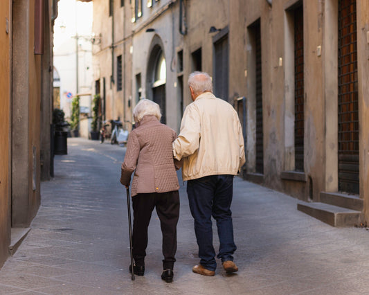 an older couple walking down a narrow street