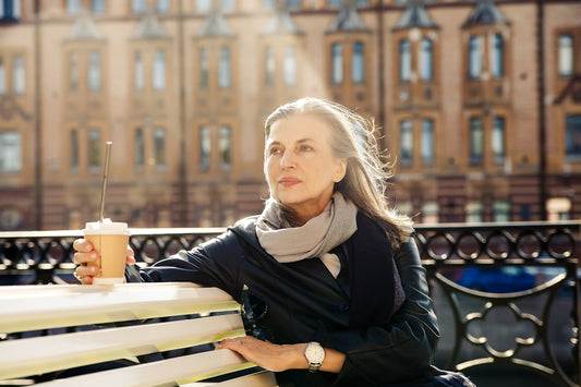 a woman sitting on a bench holding a drink