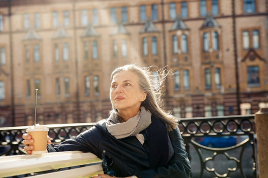 a woman sitting at a table outside