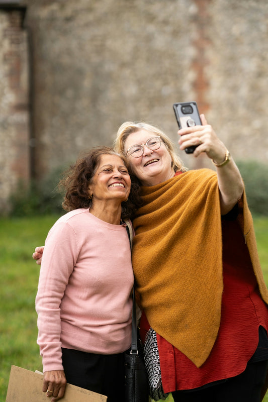 two women taking a picture with a cell phone