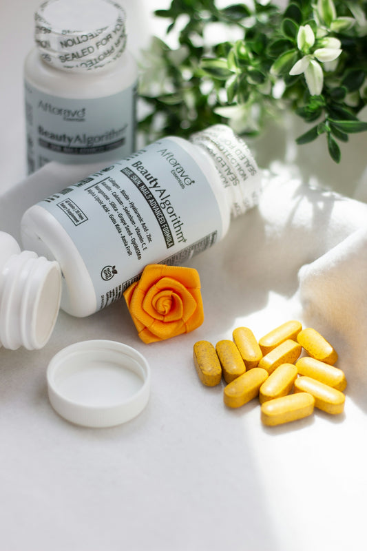 A close up of a bottle of pills next to a flower