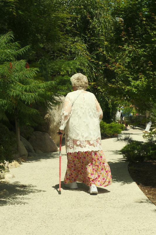A woman walking down a path with a cane