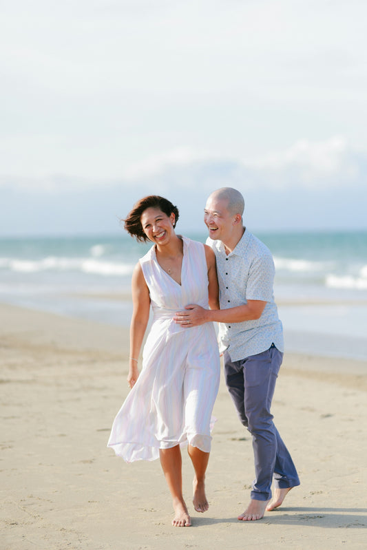 Couple walking and laughing on a beach